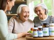 A senior individual and a caregiver discussing various vitamin and supplement bottles like Vitamin D, Calcium, B12, and Omega-3 in a cozy, well-lit home setting.